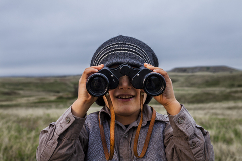 Boy wearing explorer costume holding binoculars stock photo