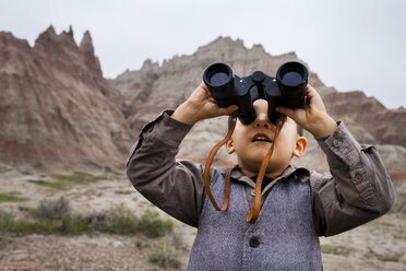 Boy wearing explorer costume holding binoculars - AURF04901