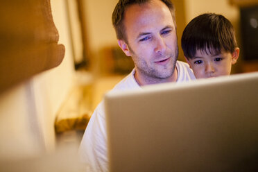 Vater und Sohn benutzen gemeinsam einen Laptop - AURF05064
