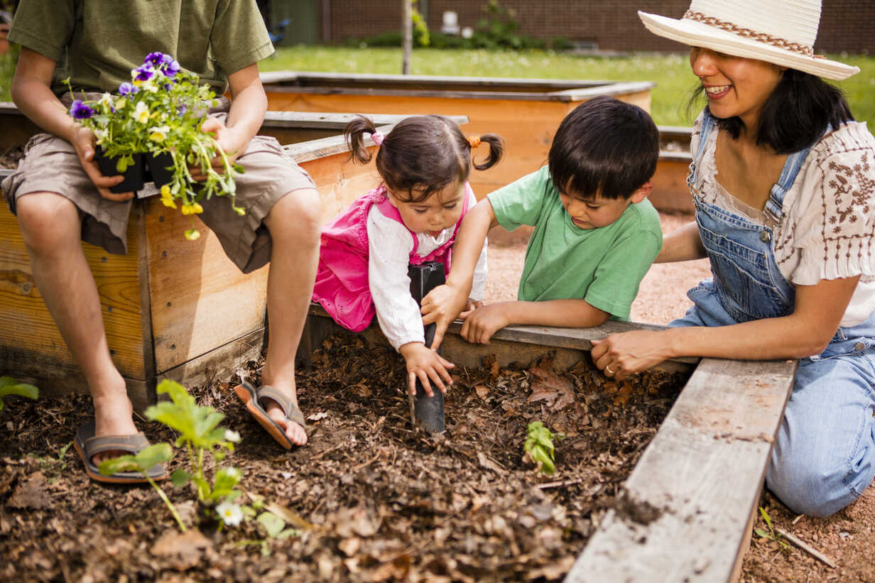 https://us.images.westend61.de/0001039469pw/japanese-american-family-planting-flowers-in-garden-AURF05188.jpg