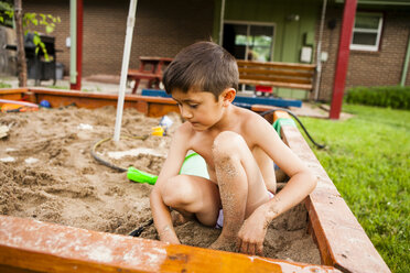 Japanese American boy playing in sandbox - AURF05189