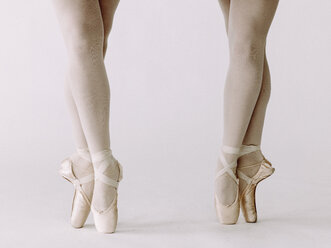Low section of two ballet dancers standing side by side en pointe - AURF05244