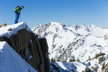 Mann schaut beim Skifahren eine Klippe hinunter, Wasatch Mountains, Utah, USA - AURF05251