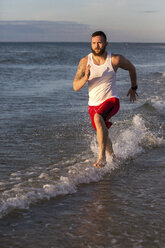 Mann läuft am Strand - AURF05260
