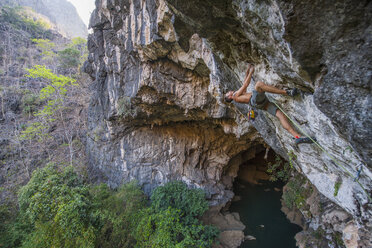 Mann klettert über einer Höhle in Thakhek - Laos - AURF05275