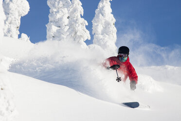 Männlicher Skifahrer macht eine Tiefschnee-Kurve im Whitefish Mountain Resort in Whitefish, Montana - AURF05282