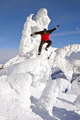 Männlicher Snowboarder springt von einem schneegeformten Geist in Whitefish, Montana, USA - AURF05291