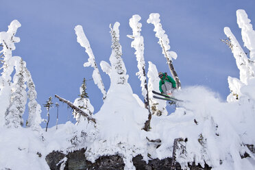 Männlicher Skifahrer springt von einer Klippe im East Rim im Whitefish Mountain Resort - AURF05294