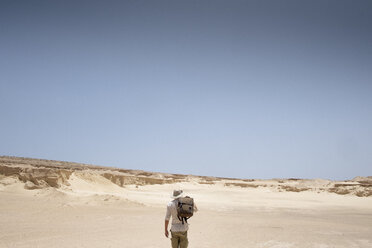 Mann mit Rucksack in der Wüste stehend - AURF05314