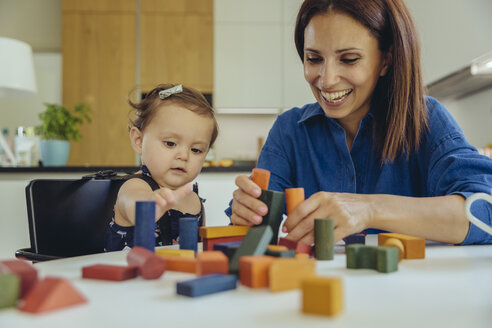 Glückliche Mutter und kleine Tochter spielen mit Bauklötzen - MFF04655