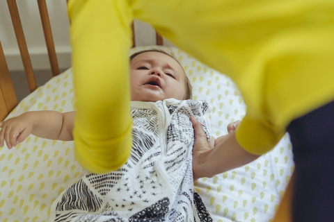 Mutter, die ihr kleines Mädchen aus dem Bett holt, lizenzfreies Stockfoto