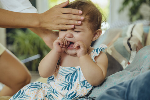 Mother taking temperature of her crying baby girl - MFF04696