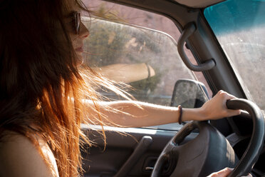 Young woman with windswept hair driving a car - AFVF01557