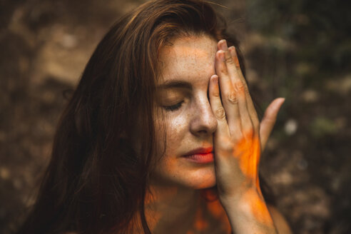 Porträt einer jungen Frau mit Sommersprossen, die ein Auge bedecken - AFVF01575