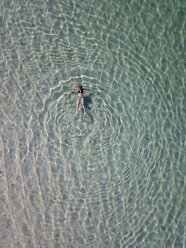 Indonesien, Bali, Luftaufnahme des Strandes Karma Kandara, eine Frau schwimmt im Wasser - KNTF01656