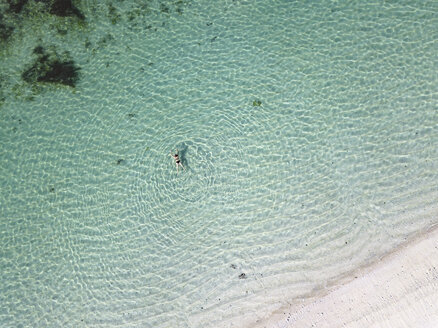 Indonesien, Bali, Luftaufnahme von Karma Kandara Strand, Frau schwimmt im Wasser - KNTF01658