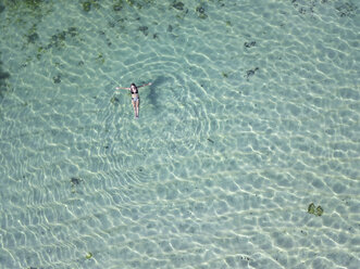 Indonesien, Bali, Melasti, Luftaufnahme von Karma Kandara Strand, Frau schwimmt auf dem Wasser - KNTF01660