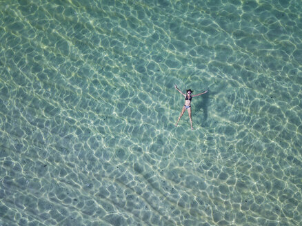 Indonesien, Bali, Melasti, Luftaufnahme von Karma Kandara Strand, Frau schwimmt auf dem Wasser - KNTF01684