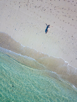 Indonesien, Bali, Melasti, Luftaufnahme des Karma Kandara Strandes, Frau liegt am Strand - KNTF01692