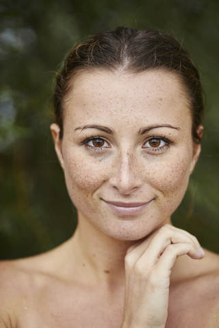Porträt einer sommersprossigen jungen Frau in der Natur, lizenzfreies Stockfoto