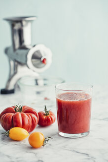 Frischer Tomatensaft in einem Glas, im Hintergrund der Fleischwolf als Entsafter - IPF00483