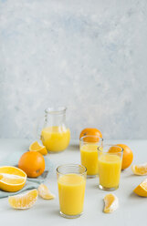 Gläser mit frisch gepresstem Orangensaft und Orangen - JUNF01260