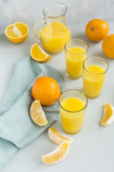 Gläser mit frisch gepresstem Orangensaft und Orangen - JUNF01261