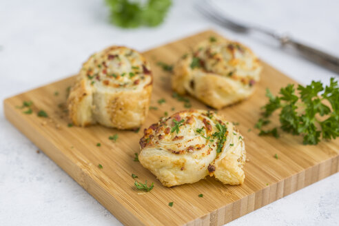 Klebrige Brötchen mit Feta, Frischkäse, Speck und Petersilie auf Holzbrett - JUNF01277