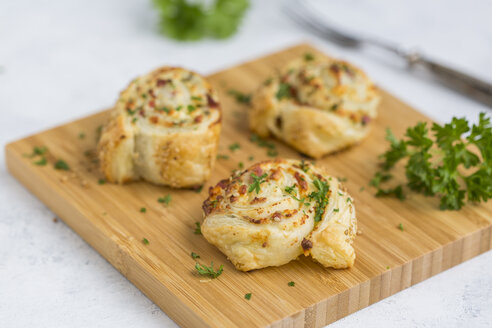 Sticky buns with feta, cream cheese, bacon and parsley on wooden board - JUNF01277