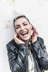 Exuberant punk woman listening to music with earbuds - GIOF04440