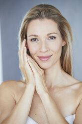 Portrait of smiling blond woman wrapped in towel - PNEF00908