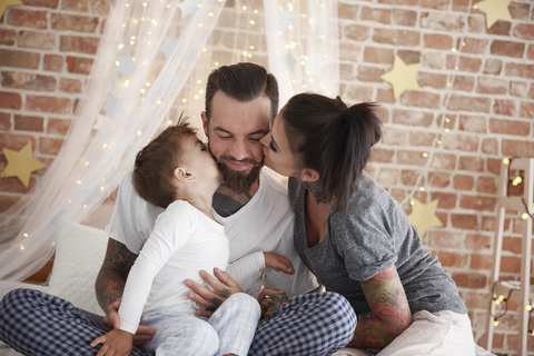 Glückliche Familie zur Weihnachtszeit im Bett, lizenzfreies Stockfoto