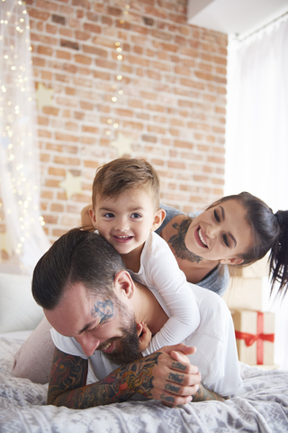 Glückliche Familie beim Spielen zur Weihnachtszeit im Bett, lizenzfreies Stockfoto