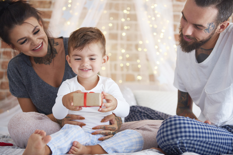 Glückliche Familie feiert Weihnachten im Bett, lizenzfreies Stockfoto