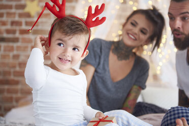 Cute boy in reindeer costume at Christmas time in bed - ABIF01031