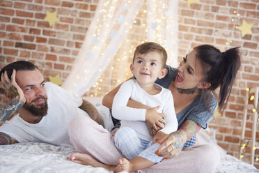 Glückliche Familie zur Weihnachtszeit im Bett - ABIF01034