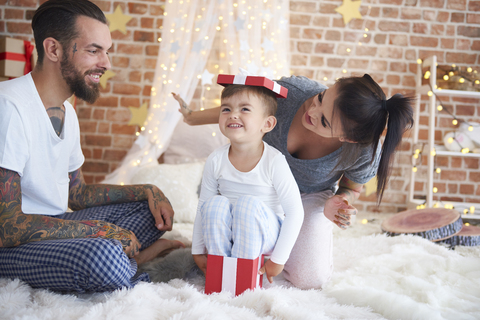 Glückliche Familie, die sich zu Weihnachten im Bett amüsiert, lizenzfreies Stockfoto