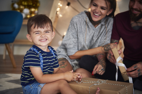 Portrait of boy opening Christmas present at home stock photo