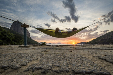 Mann in Hängematte bei Sonnenaufgang in Rio de Janeiro, Brasilien - AURF05440