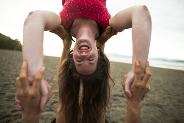 Mann und Frau machen Acroyoga am Strand - AURF05484