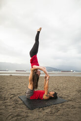 Mann und Frau machen Acroyoga am Strand - AURF05485