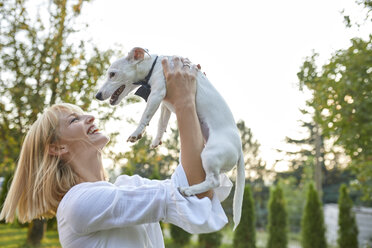 Glückliche Frau mit Hund und Fliege im Freien - ZEDF01554