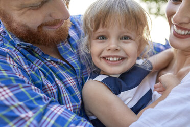 Happy parents hugging her daughter outdoors - ZEDF01565