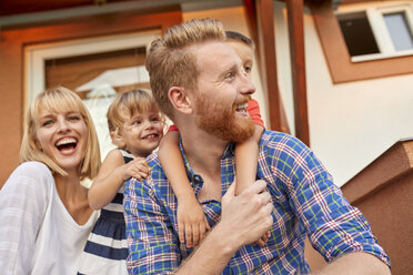 Happy family on porch of their home - ZEDF01567