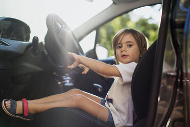 Portrait of little boy sitting on driver's seat in a car - AZOF00054