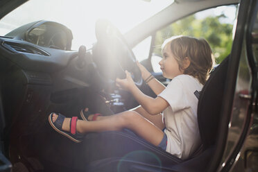 Glücklicher kleiner Junge auf dem Fahrersitz in einem Auto - AZOF00055