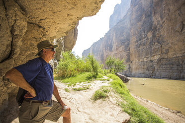 Älterer Mann erkundet den Brown River in einem steilwandigen Wüstencanyon - AURF05537