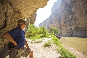 Senior Man Exploring Brown River In A Steep-walled Desert Canyon - AURF05537