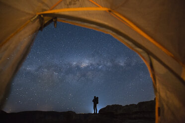 Silhouette of backpacker standing against starry night sky, New South Wales, Australia - AURF05555