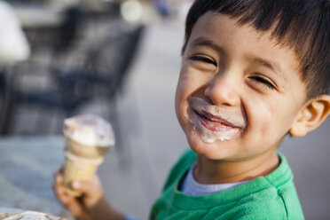 Lächelnder japanisch-amerikanischer Junge mit schmutzigem Gesicht nach dem Verzehr von Eiscreme - AURF05591